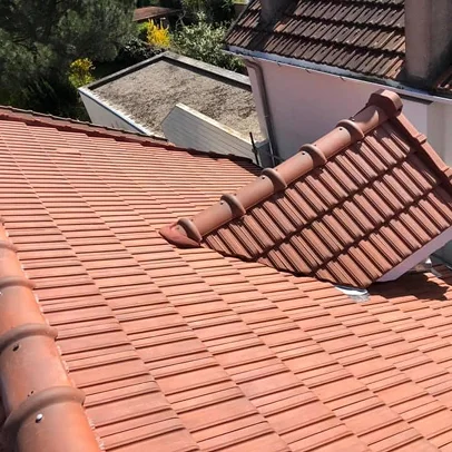 Toit en tuiles de terre cuite, avec une lucarne, sous le soleil, entreprise couverture à Sartrouville dans les Yvelines 78