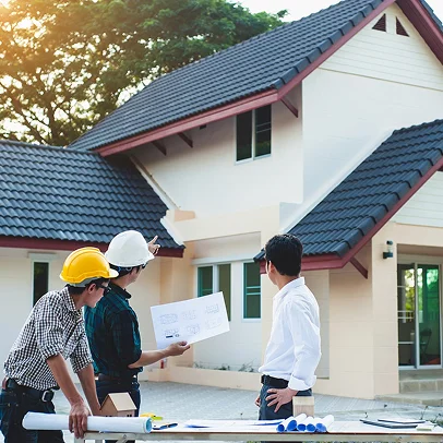 Trois hommes discutent de plans de construction devant une nouvelle maison à Sartrouville dans les Yvelines 78