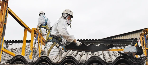 Des ouvriers en équipement de protection retirent des tuiles de toit amiantées à Sartrouville dans les Yvelines 78