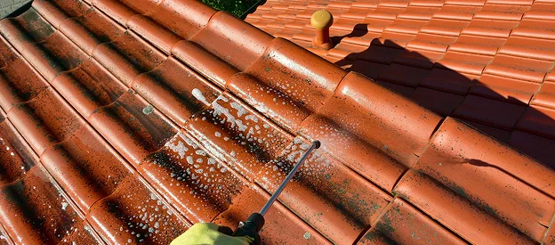 Nettoyage haute pression d'un toit en tuiles rouges sales avec du savon à Sartrouville dans les Yvelines 78