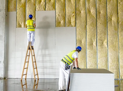 Ouvriers installant des panneaux de gypse sur une isolation murale à Sartrouville dans les Yvelines 78